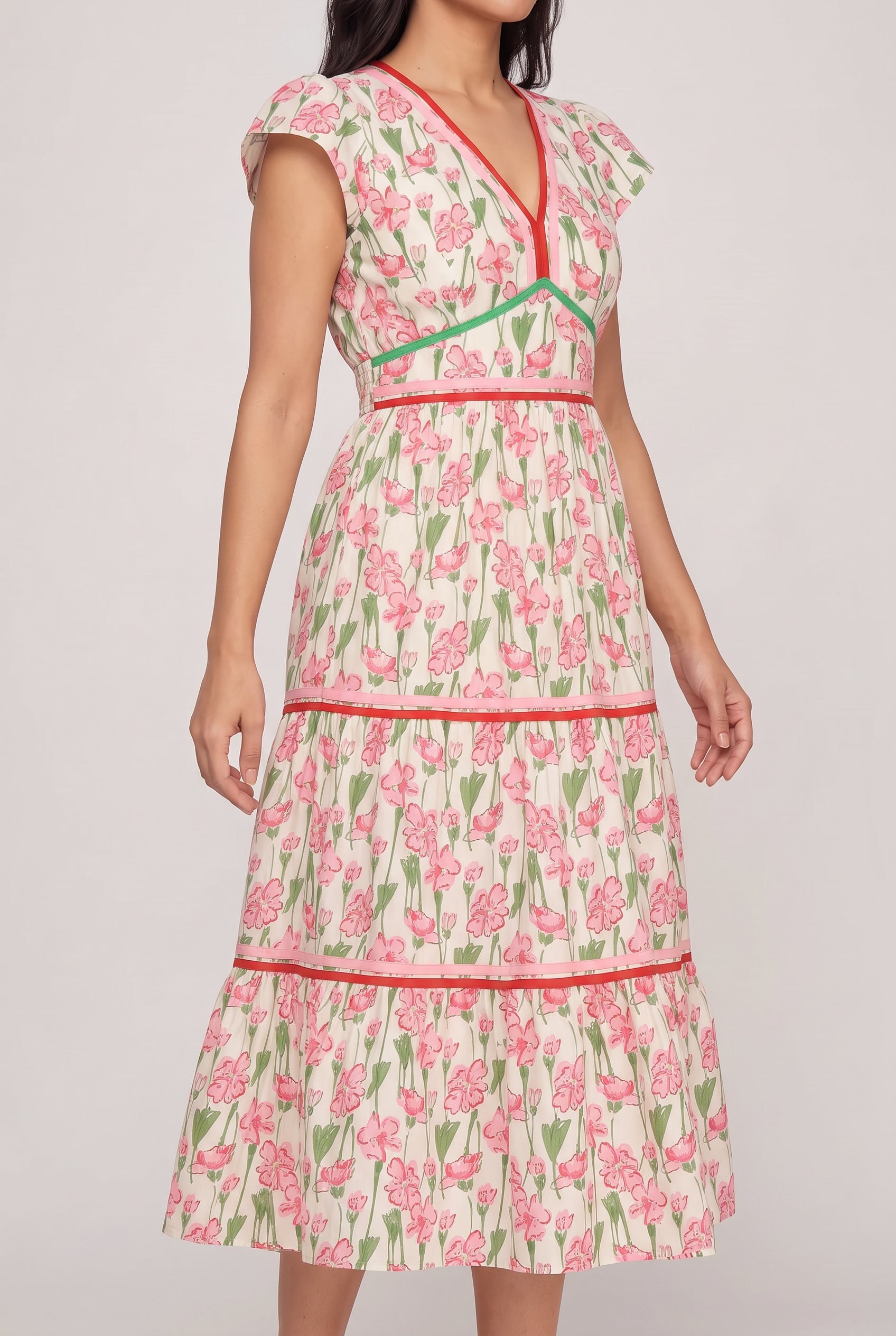Angled side fit of the floral poplin dress showing the flutter sleeve and tiered skirt volume.