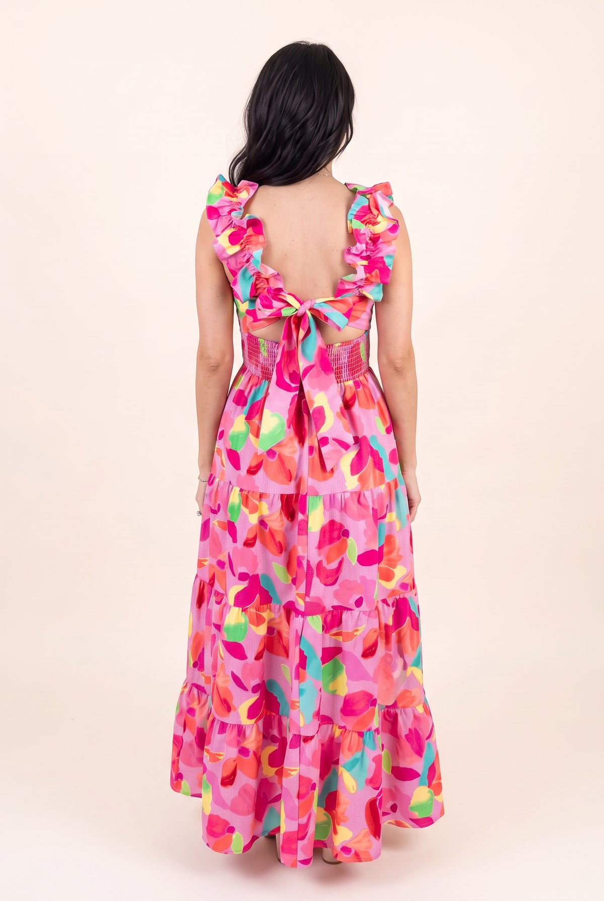 Back view of Blooming Affair floral maxi dress showing the low open back, bow tie and smocked waist.