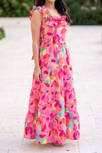 Blooming Affair floral maxi dress worn on a sunny patio, showing the ruffled neckline and ankle length tiers.