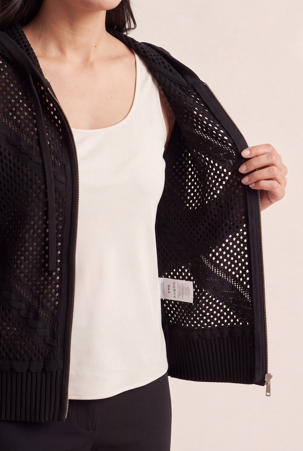 Inside of the Got My Reasons Crochet Zip Hoodie showing zipper backing, seam finish and care label.