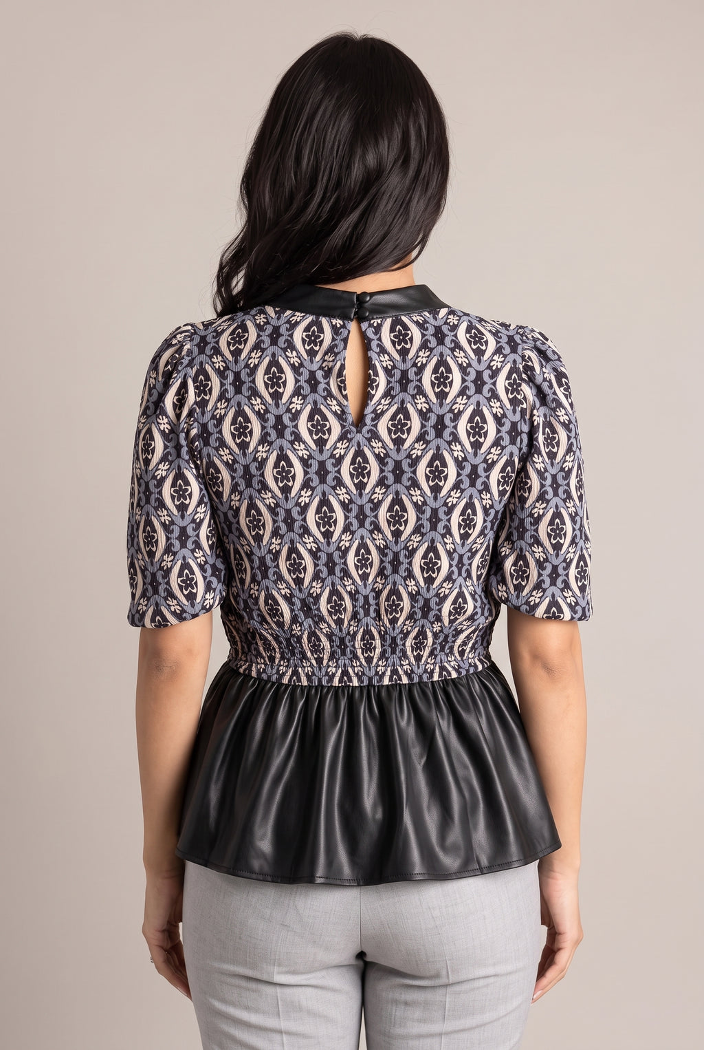 Back of the Last Night peplum top showing the keyhole closure, covered buttons and gathered waist.
