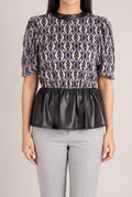 Last Night vegan leather peplum top on Shweta, showing the fitted front and flared waist.