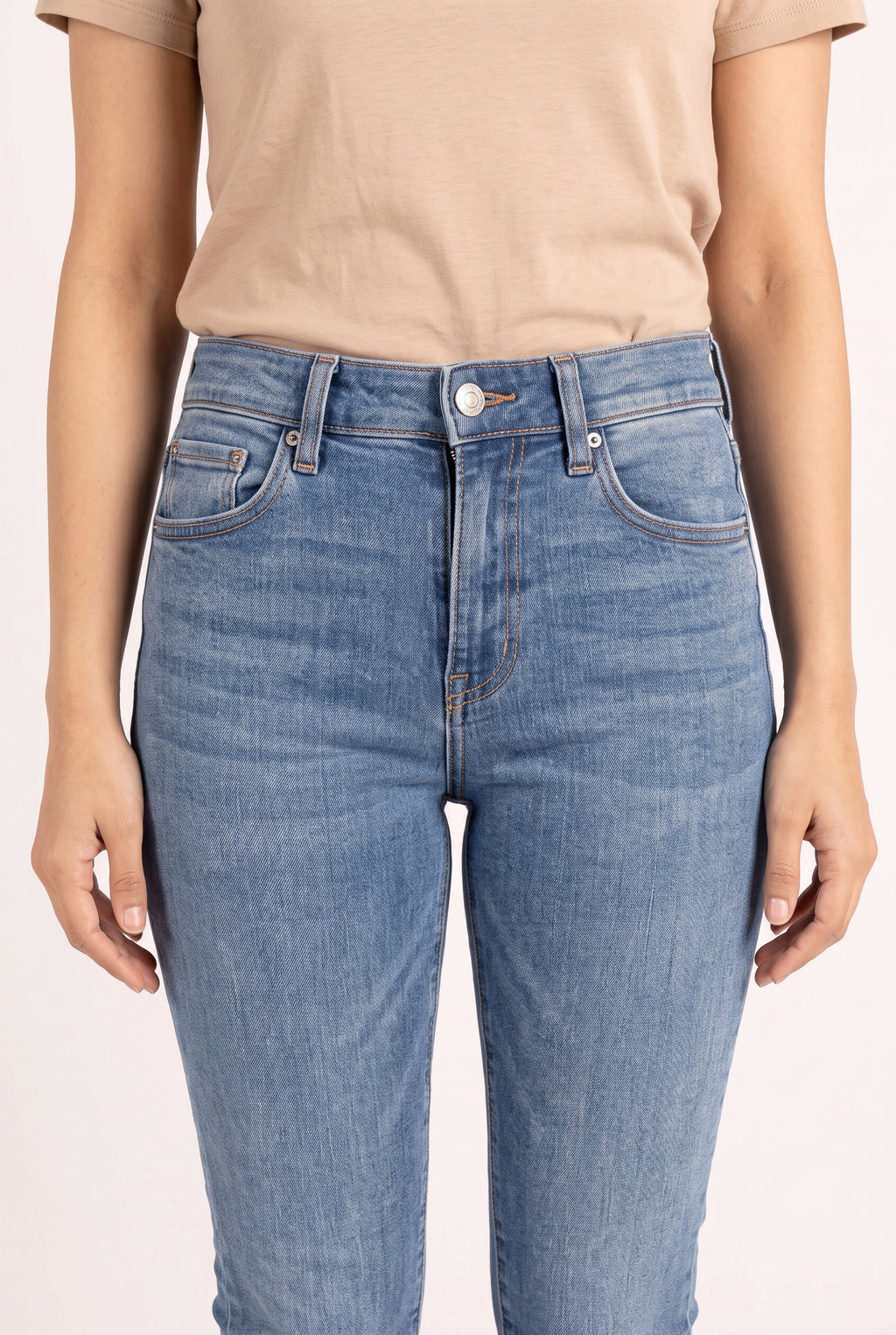 Waist detail of Bold Adventures Skinny Jeans showing the button, pockets, stitching and faded blue denim.