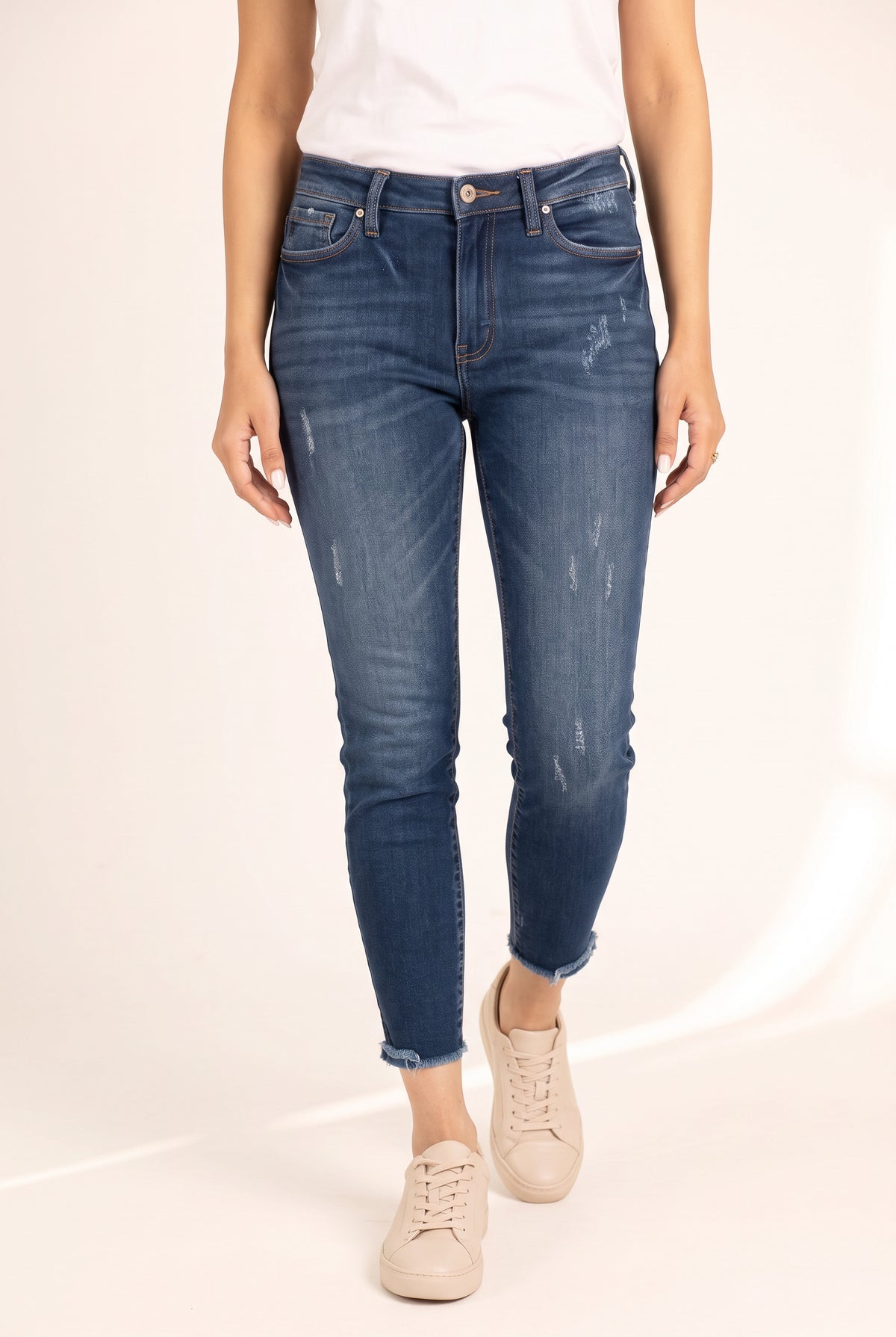 Close detail of Beautiful Day jeans showing the blue wash, light abrasions and frayed raw ankle hems.