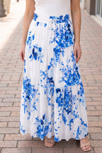 Close view of the blue floral maxi skirt’s smocked waist, drawstring and ruffled tier seam.