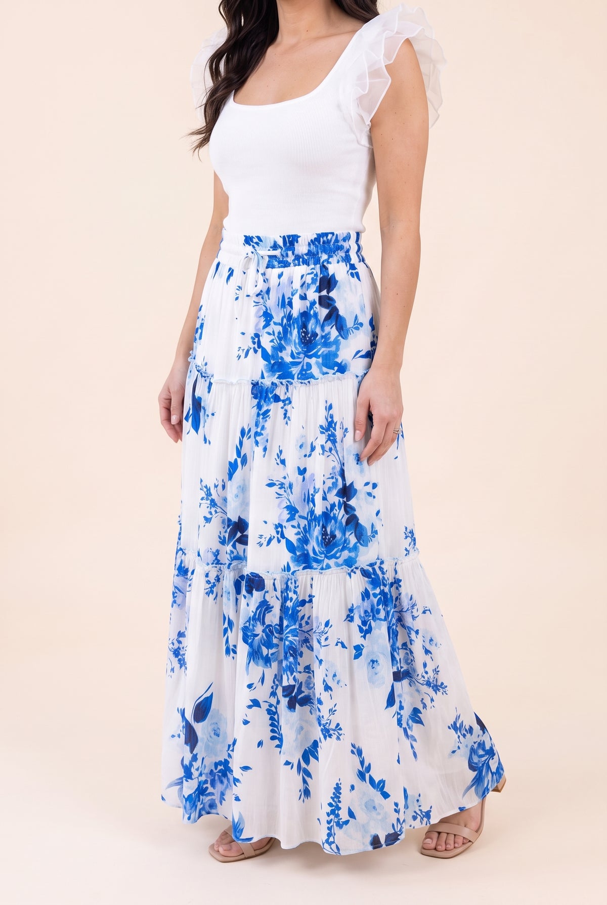Angled side fit of the blue floral tiered maxi skirt showing its volume and maxi length.