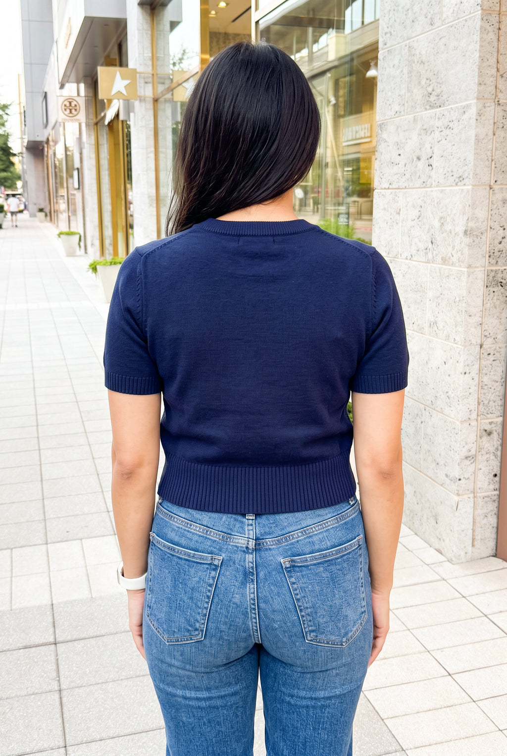 Square back fit of the navy teddy bear sweater top in Small showing its plain knit and ribbed hem.