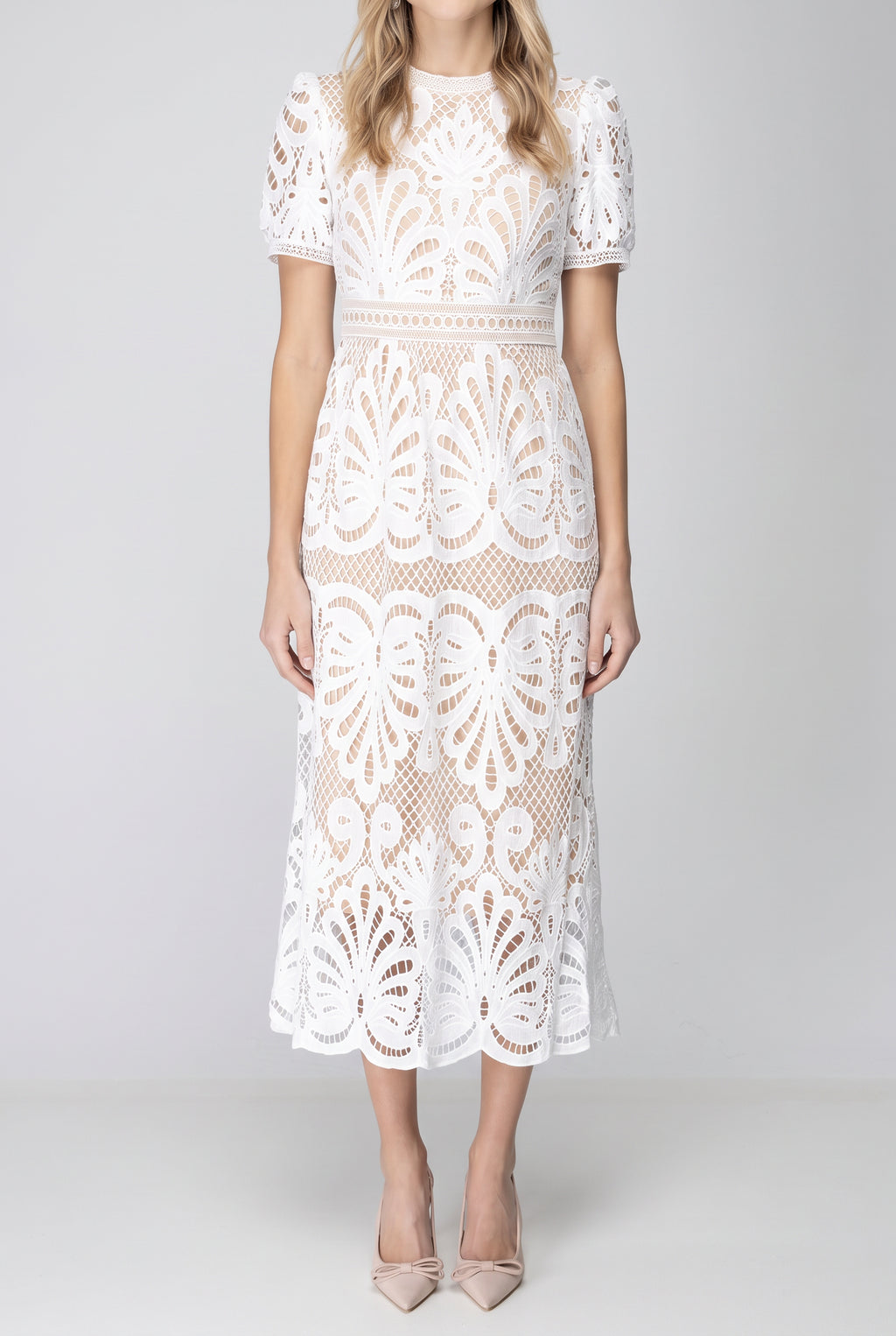 Front fit of the white crochet lace midi dress showing its waist, A-line skirt and scalloped hem.