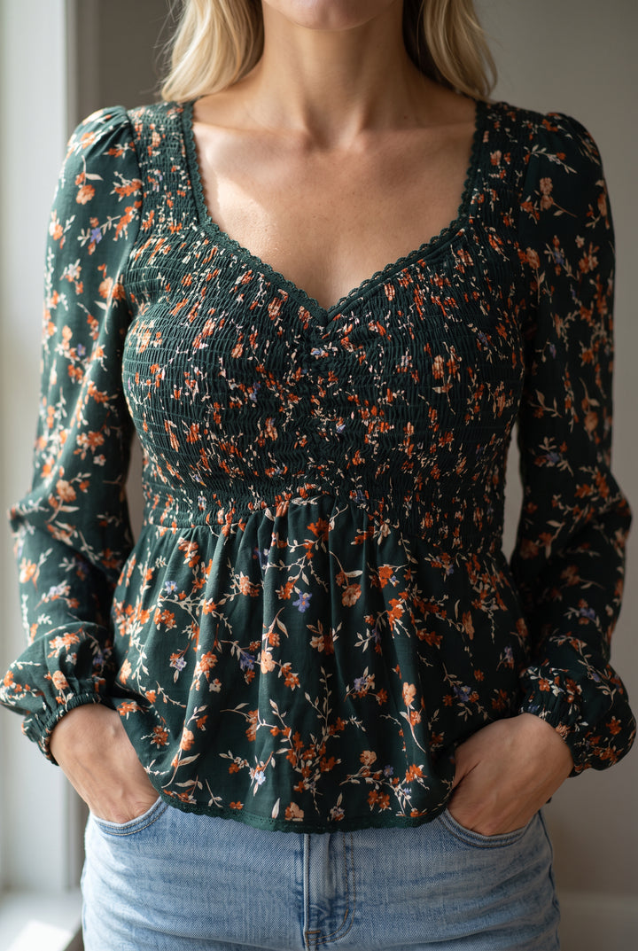 Close view of the floral top's sweetheart trim, print and elastic smocking on the fitted bodice.