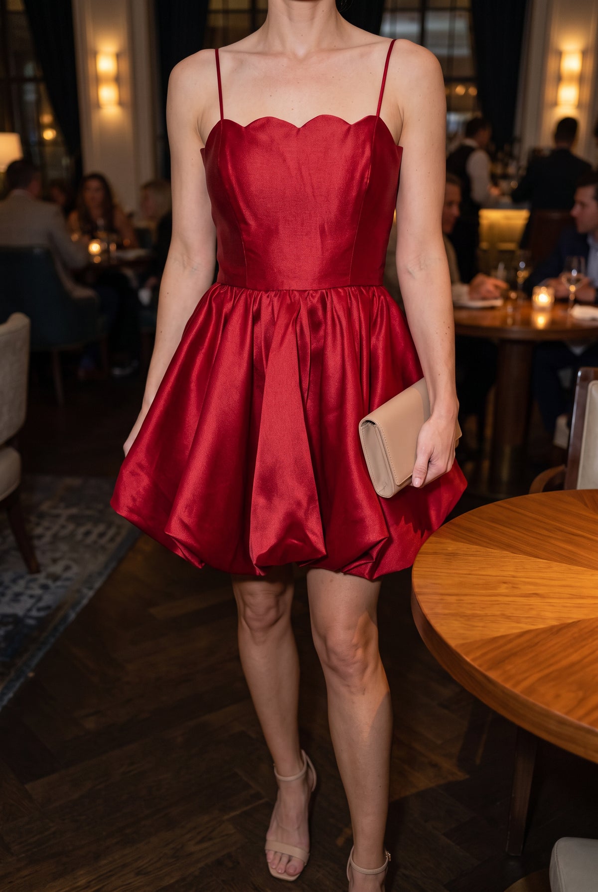 Red scallop bubble mini dress styled with heels and a clutch in an evening cocktail lounge.