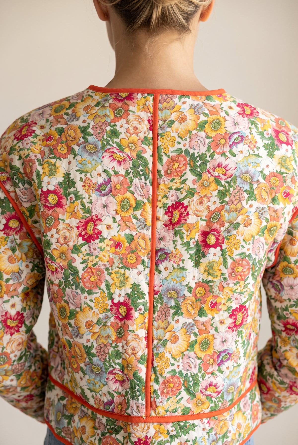 Upper back of the Good Feeling Cotton Jacket showing the curved yoke and orange-piped center seam.