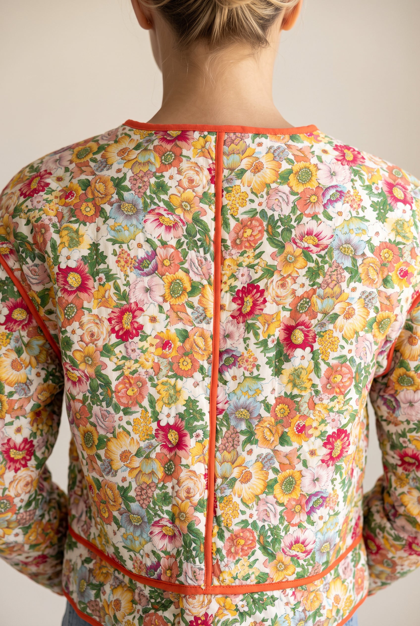 Upper back of the Good Feeling Cotton Jacket showing the curved yoke and orange-piped center seam.