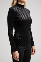 Angled side fit of the Everybody Needs Someone velvet checker top with its long sleeve and untucked hem.