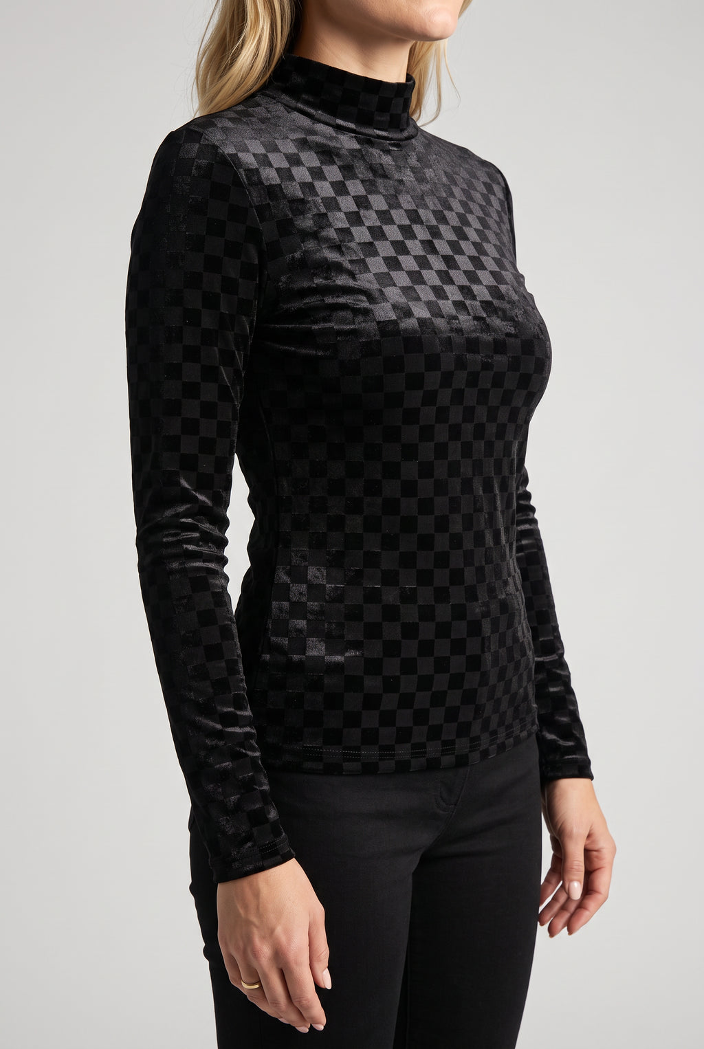 Angled side fit of the Everybody Needs Someone velvet checker top with its long sleeve and untucked hem.