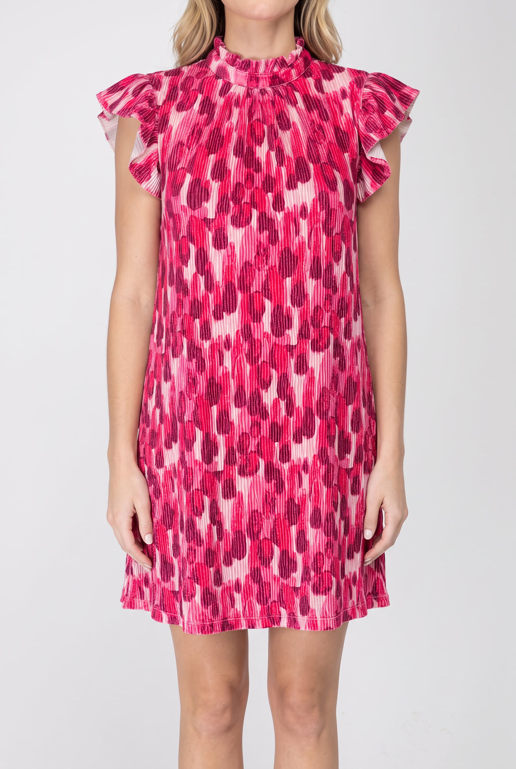 Front view of the pink pleated velvet shift dress showing its loose fit, flutter sleeves and mini length.