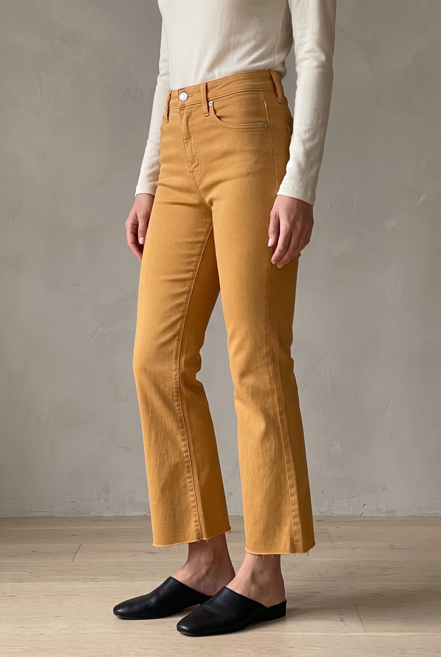 Angled side fit of Gold size 25 pants showing the close thigh, knee break and cropped kick flare.