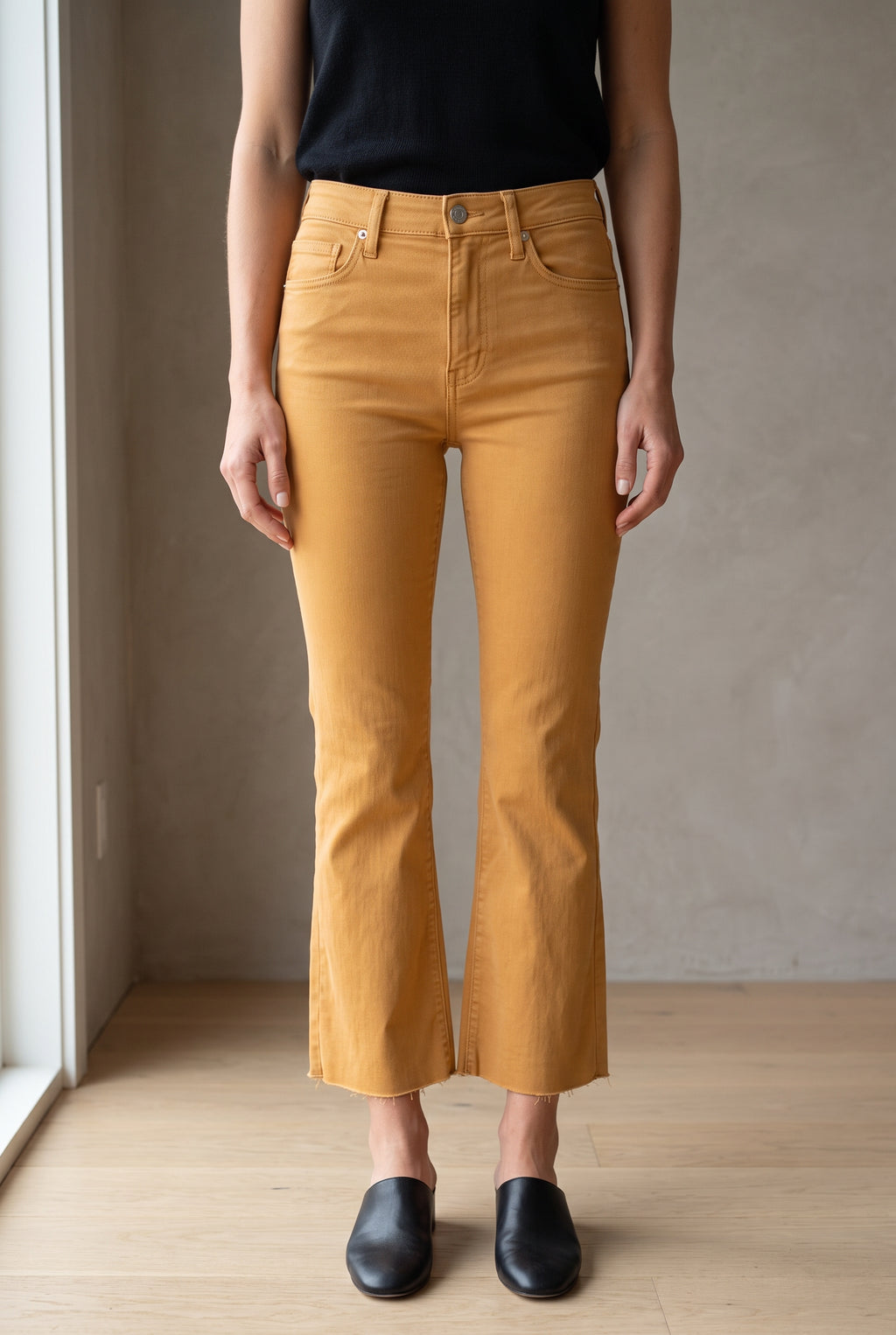 Front fit of Gold size 25 kick-flare pants showing the high rise, fitted thigh and cropped raw hem.