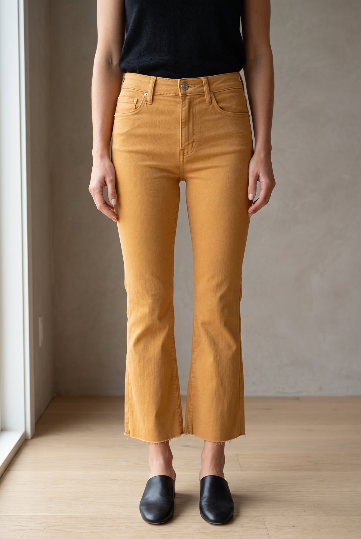 Front fit of Gold size 25 kick-flare pants showing the high rise, fitted thigh and cropped raw hem.