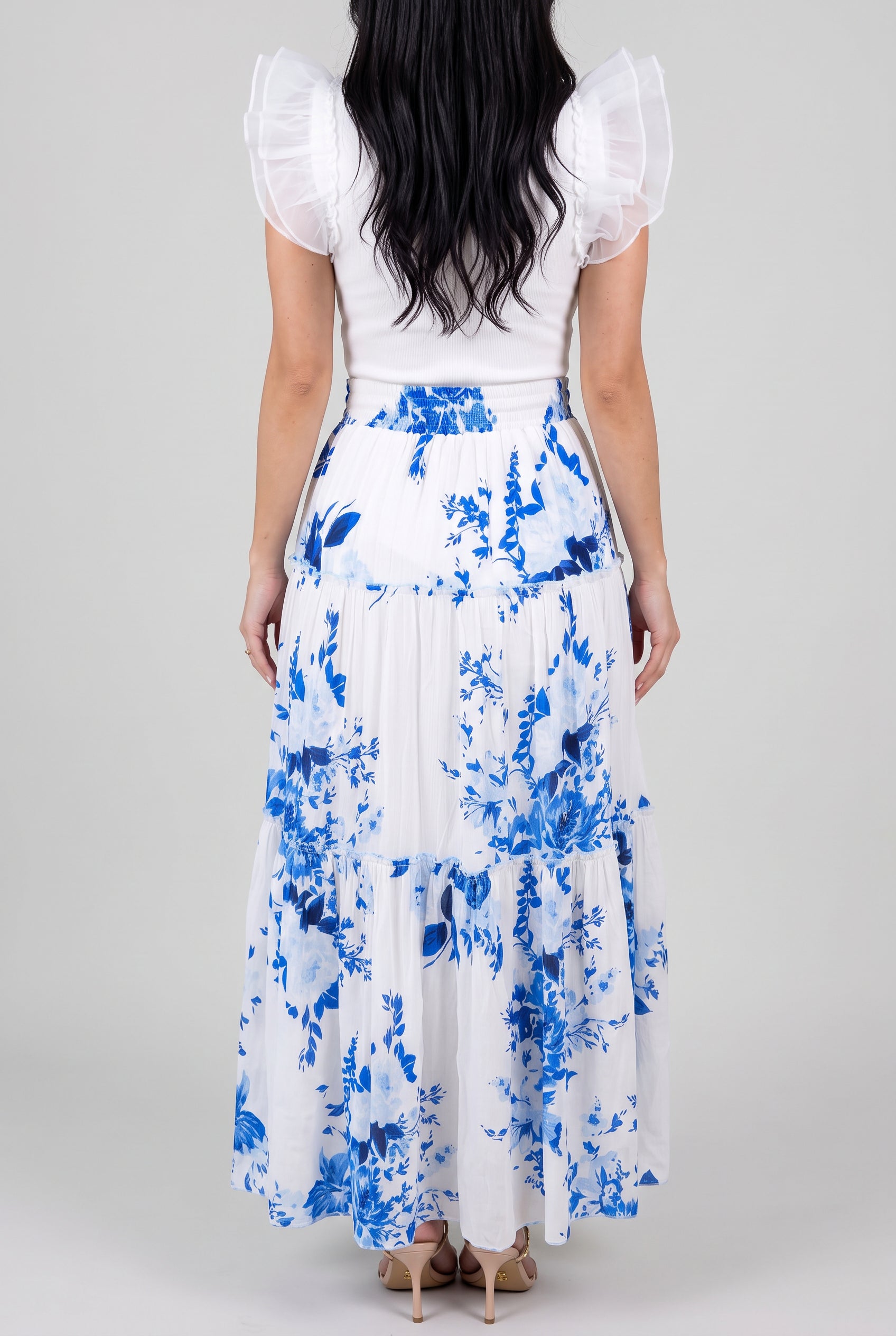 Back fit of the blue floral tiered maxi skirt showing the smocked waist and natural tiered drape.