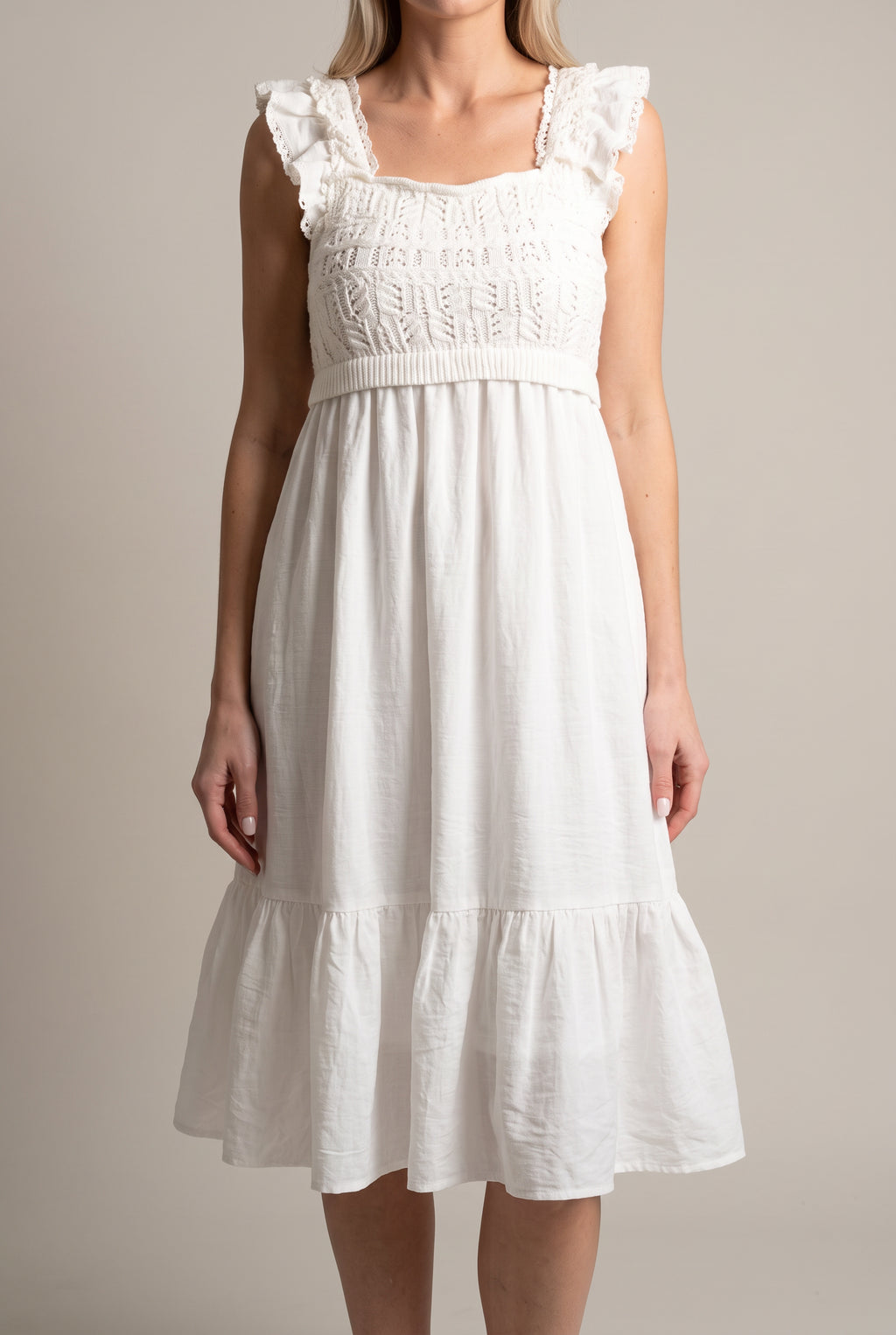 Front fit of the white crochet midi dress showing its empire waist and tiered skirt.