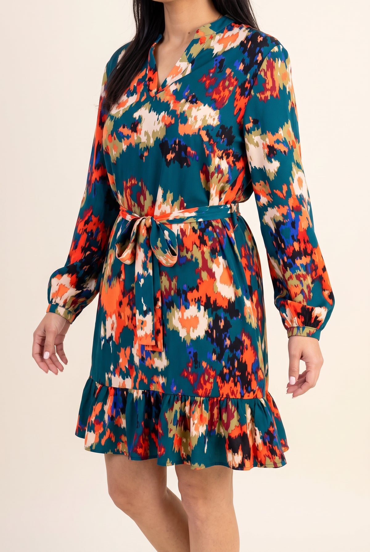 Angled side view of Shweta wearing the Small Teal ruffled mini dress.