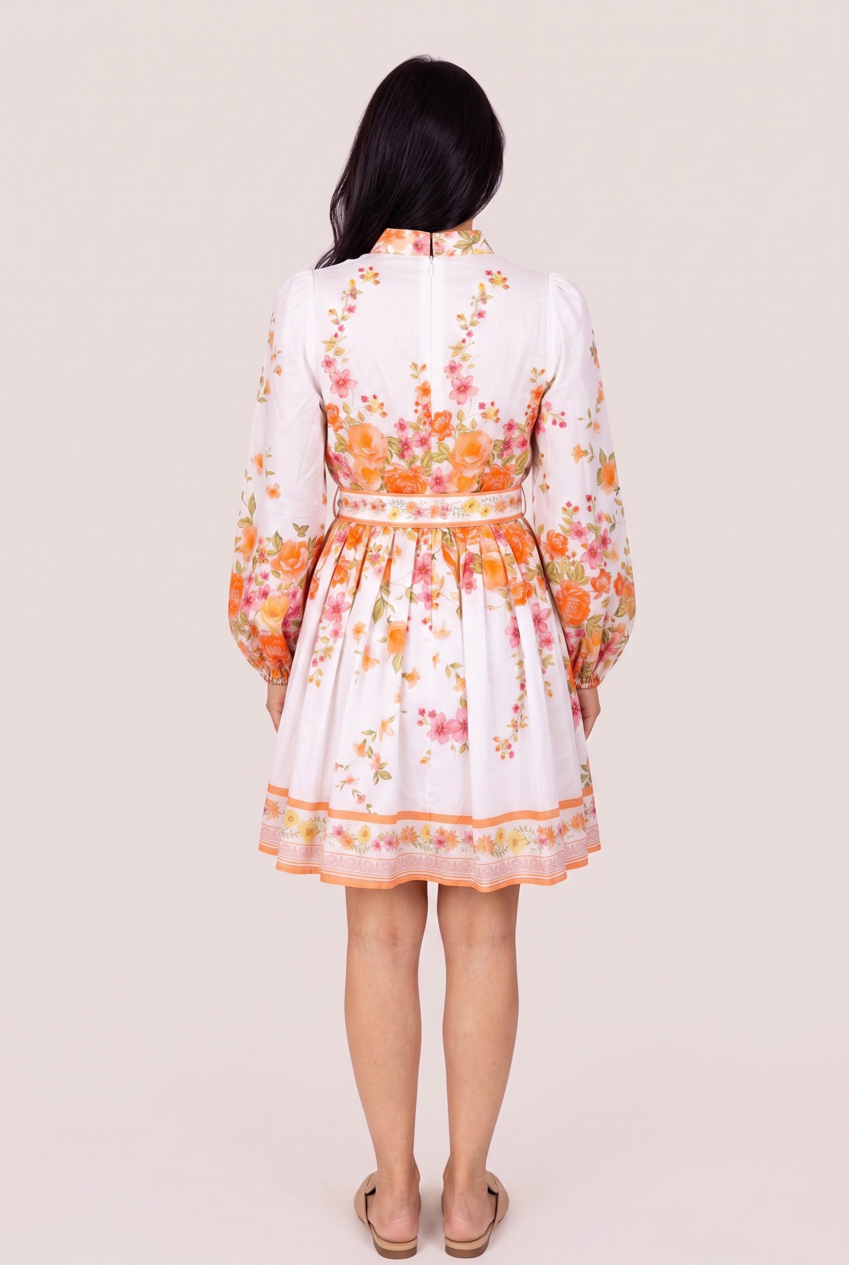 Back of the Sweet Sunshine floral mini dress showing its zipper, fitted waist and continuous border hem.