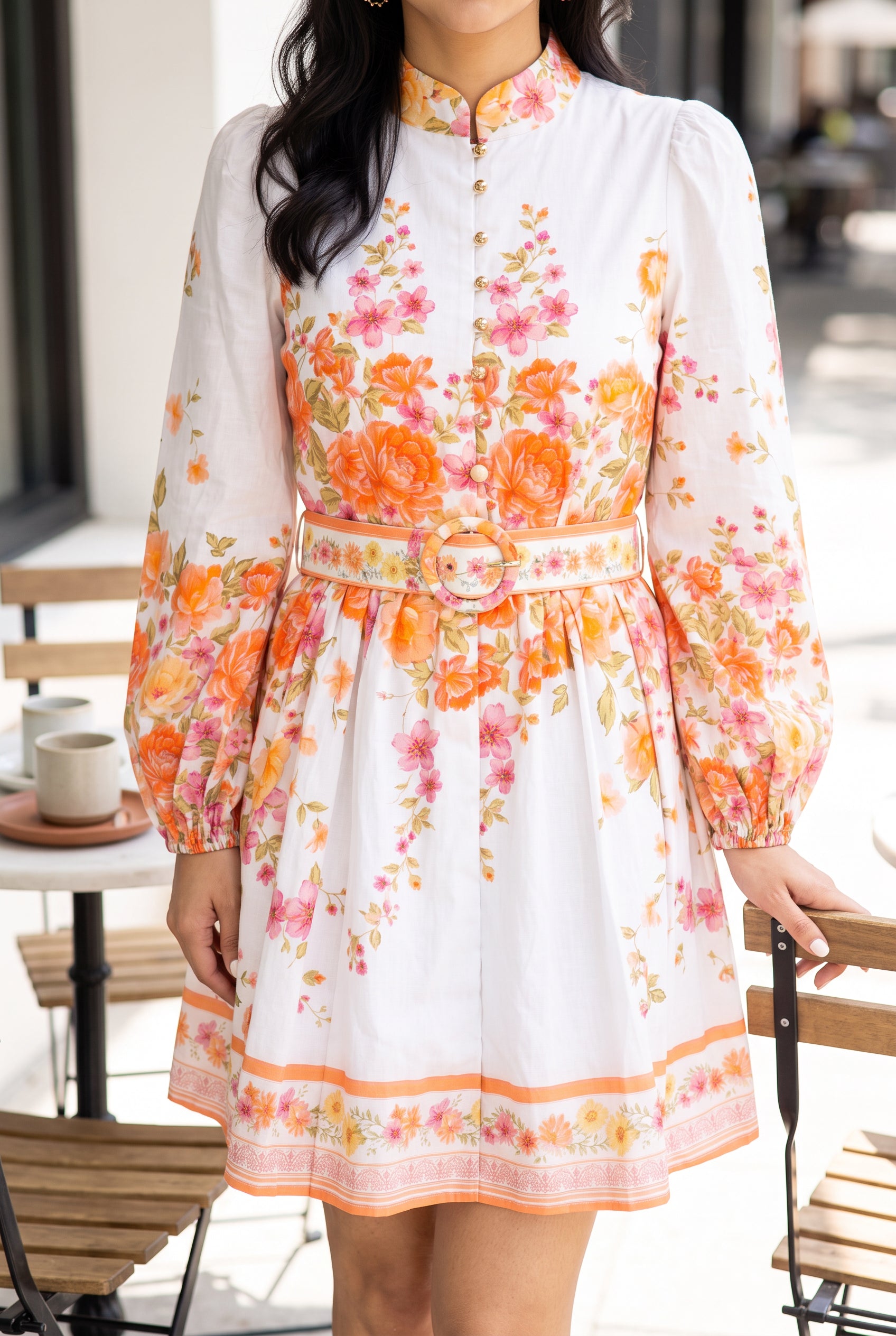 Sweet Sunshine floral mini dress styled for a sunny brunch with its belted waist and border hem visible.