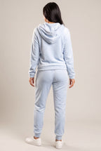 Rear three-quarter view of the light blue plush hoodie and jogger set with the hood down.