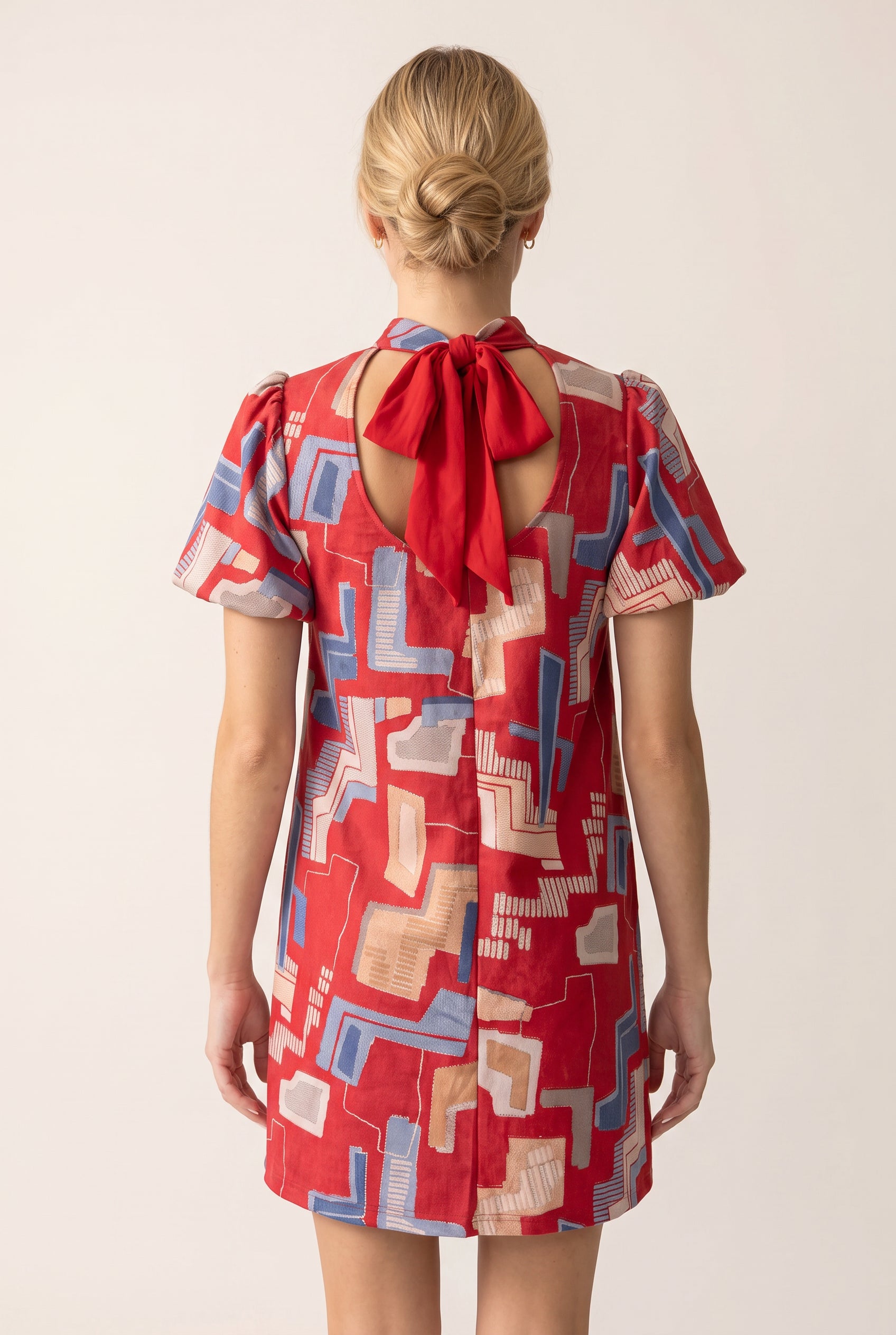 Full back of the Bold Statement Tie Back Dress showing its keyhole, bow and rear hem.