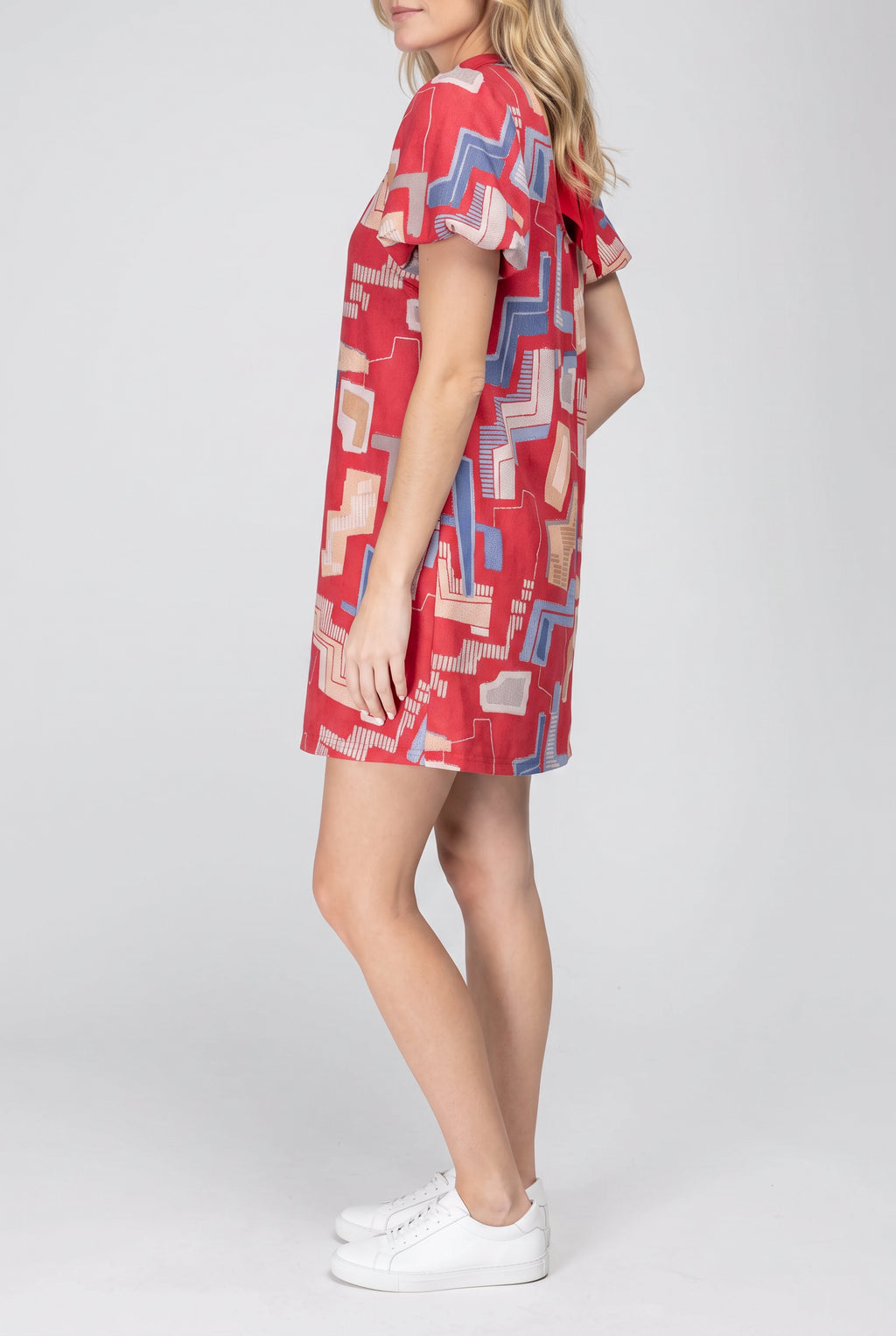 Angled side fit of the red printed mini dress showing sleeve volume and body depth.