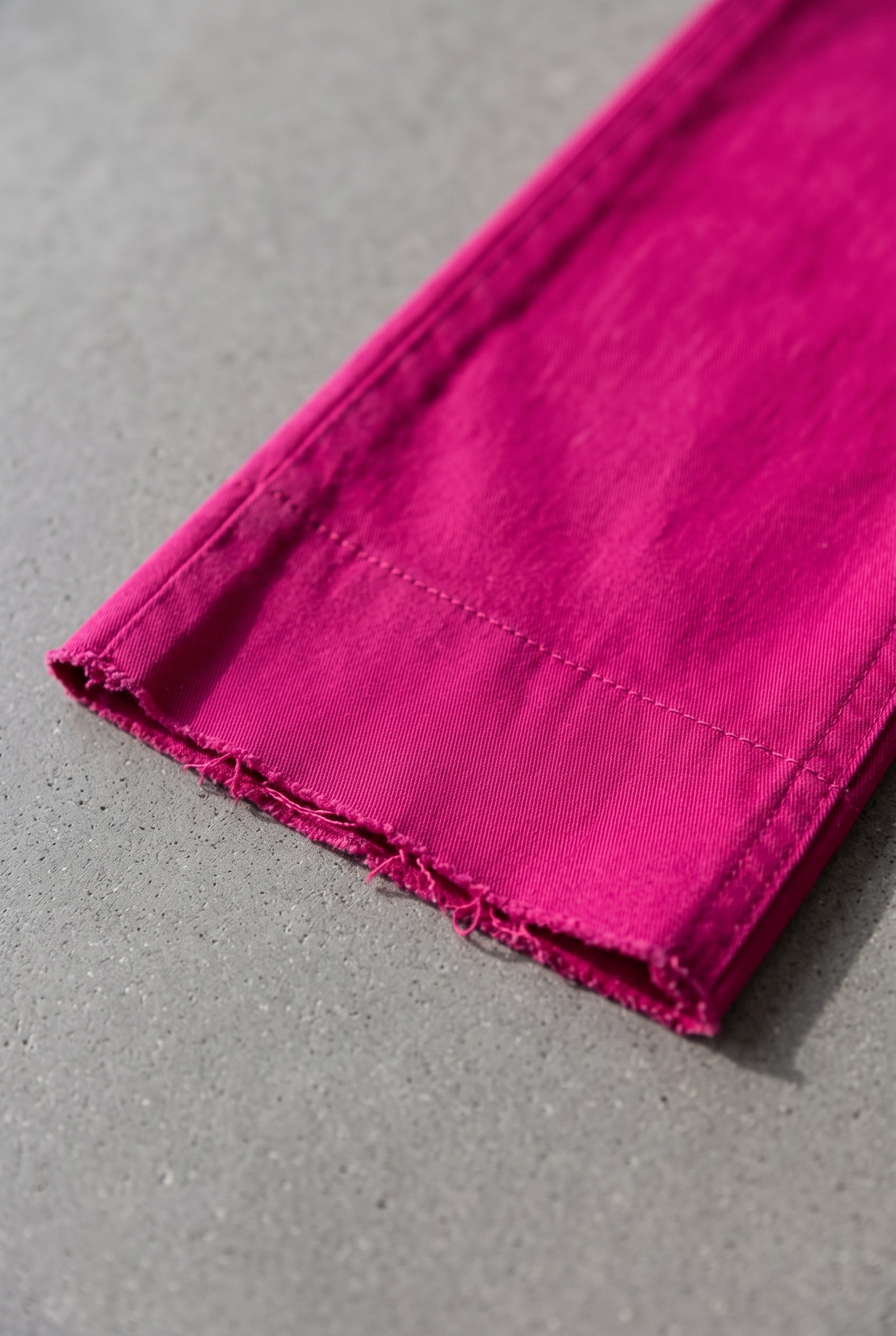 Bright Side High Rise Straight Pants close-up showing the Fuchsia fabric and raw-cut hem.