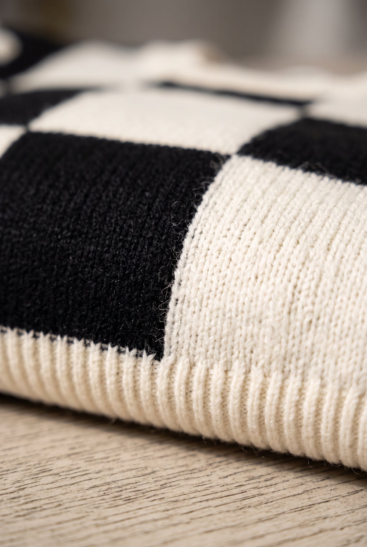 Close detail of the Checkmate Chic sweater’s checkerboard knit and ribbed hem.