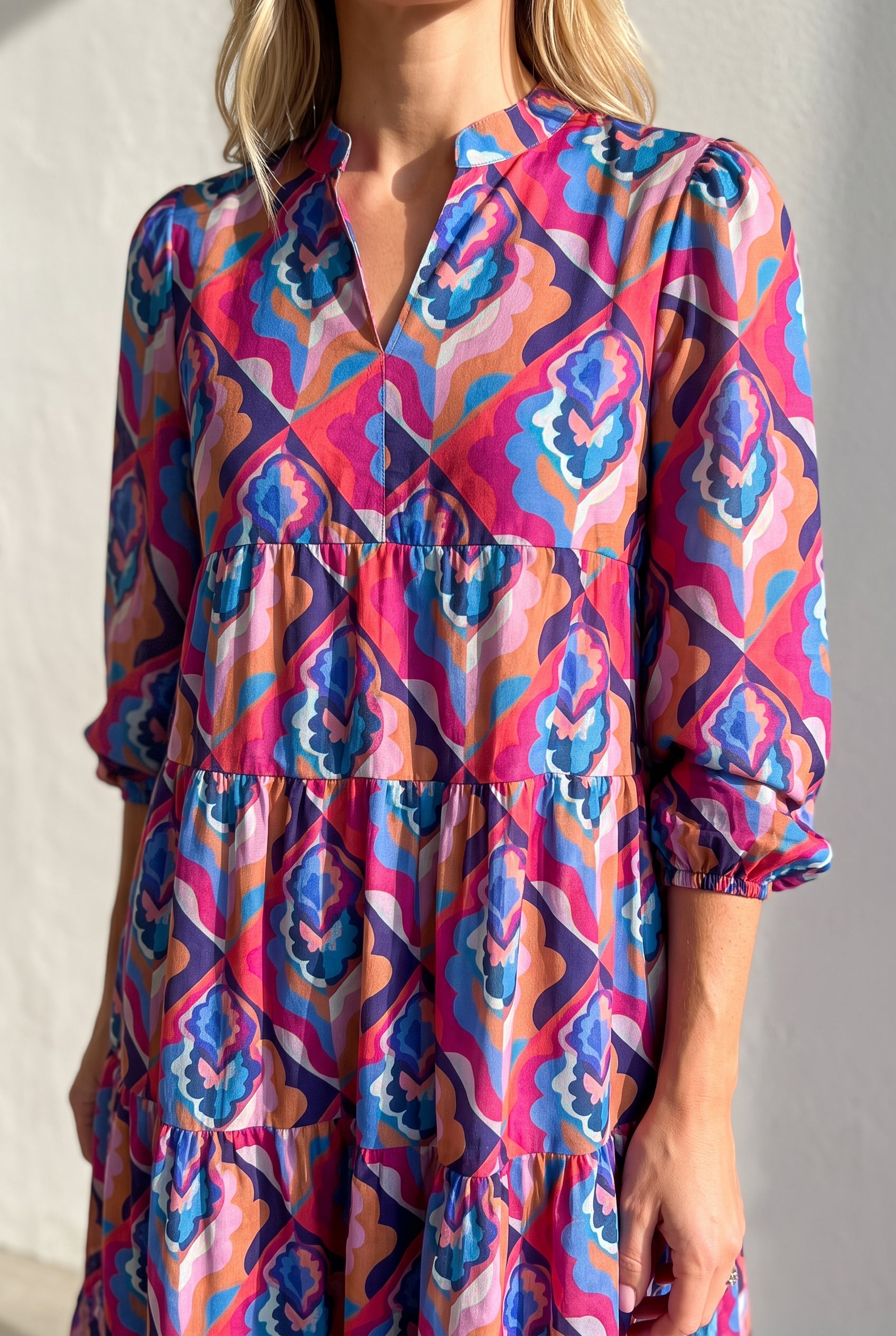 Calling You dress detail showing the split neckline, gathered seam, sleeve cuff and geometric print.