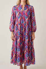 Front view of the Calling You long sleeve tiered dress in a retro magenta and blue geometric print, with split neckline and balloon sleeves.