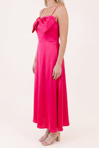 Angled side view of the Fuchsia Bow-tiful You Midi Dress showing the bow projection and skirt drape.