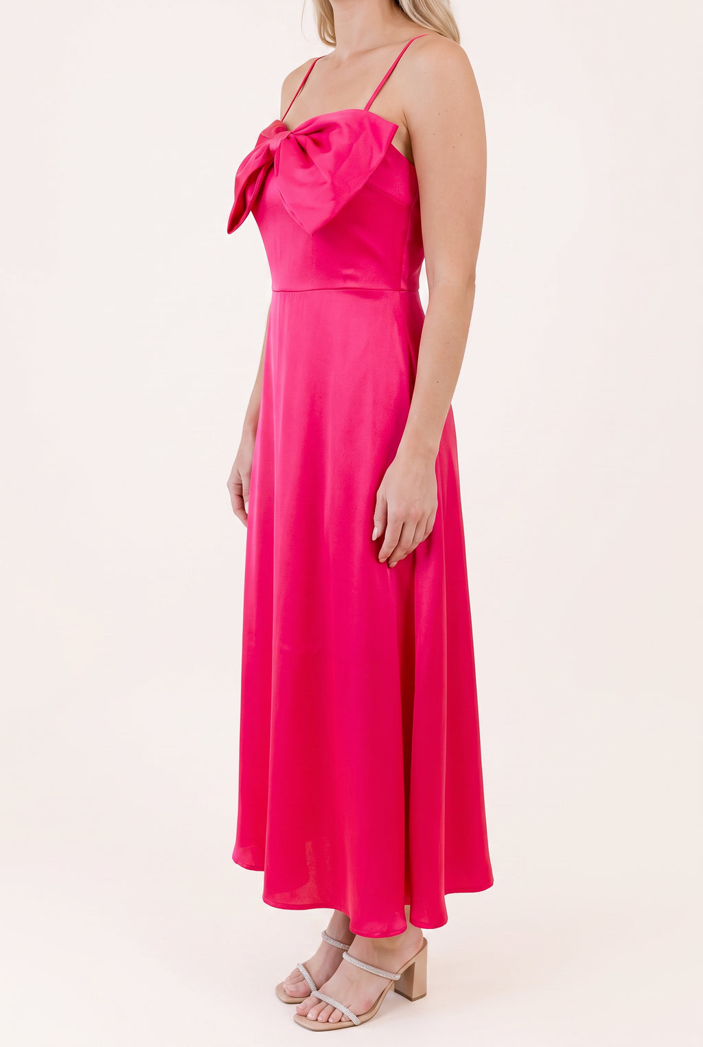 Angled side view of the Fuchsia Bow-tiful You Midi Dress showing the bow projection and skirt drape.