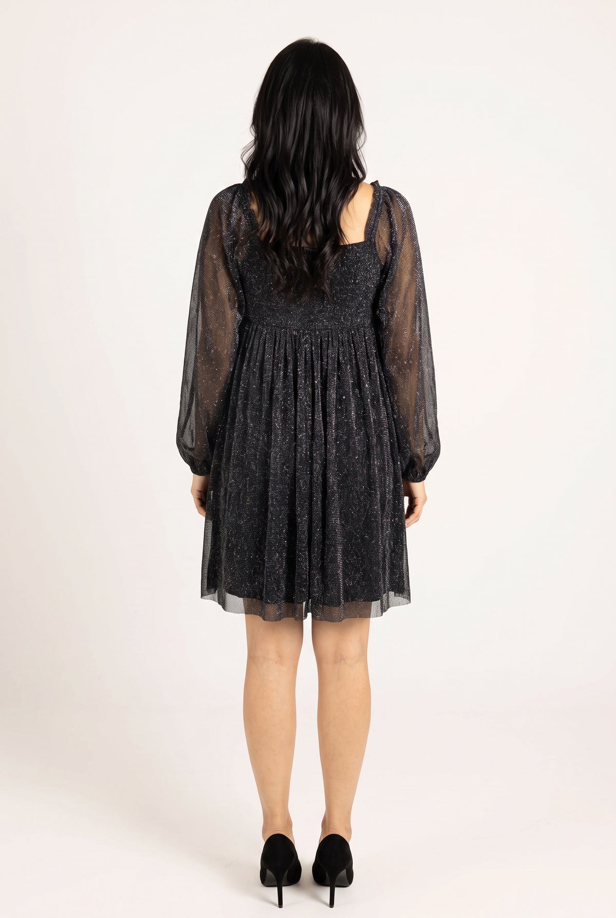 Back fit of the black glitter babydoll dress showing the lower square back and gathered skirt.