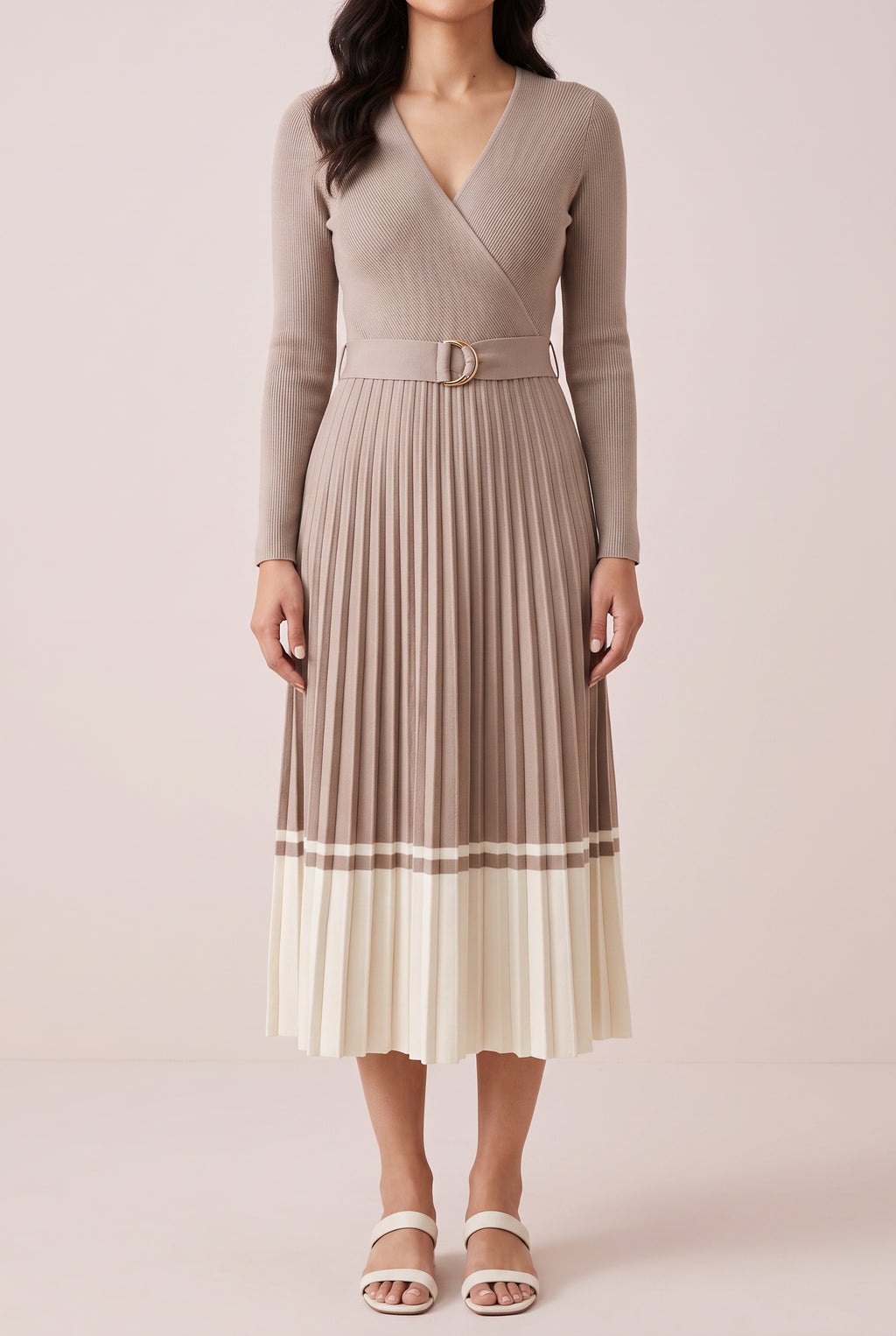 Angled side fit of the beige pleated sweater dress in Small, showing its waist and midi length.