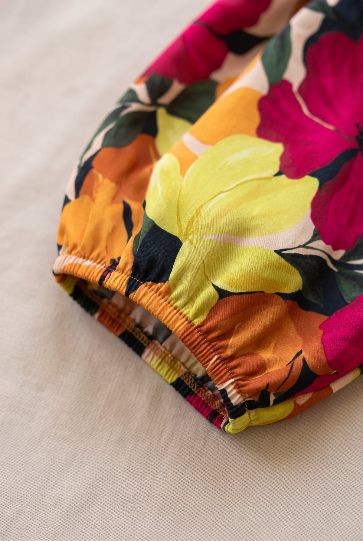 Close-up of the floral dress fabric, elasticated bubble-sleeve cuff and stitching.