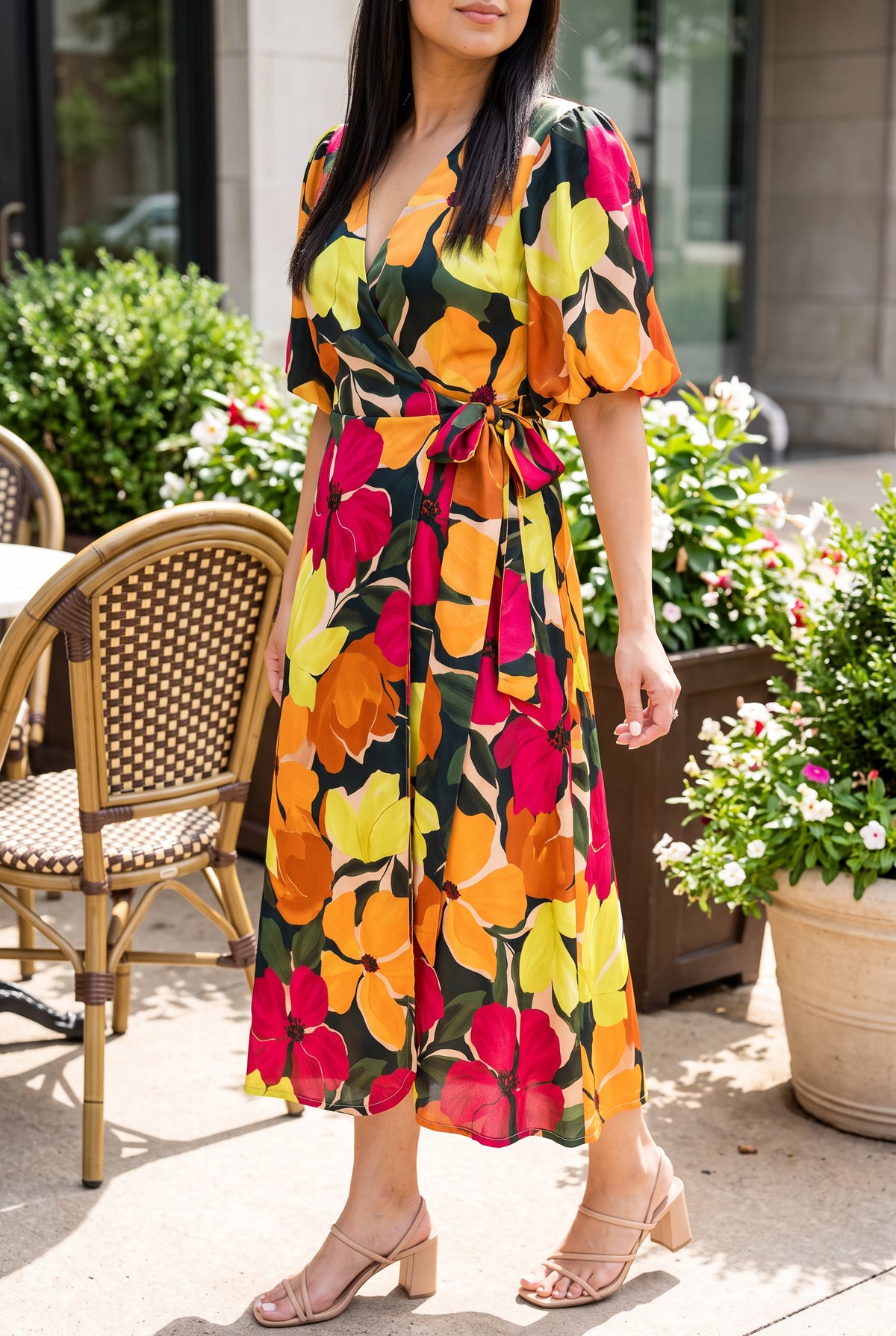 Angled side view of the floral wrap midi dress showing its bubble sleeve, waist tie and skirt fall.