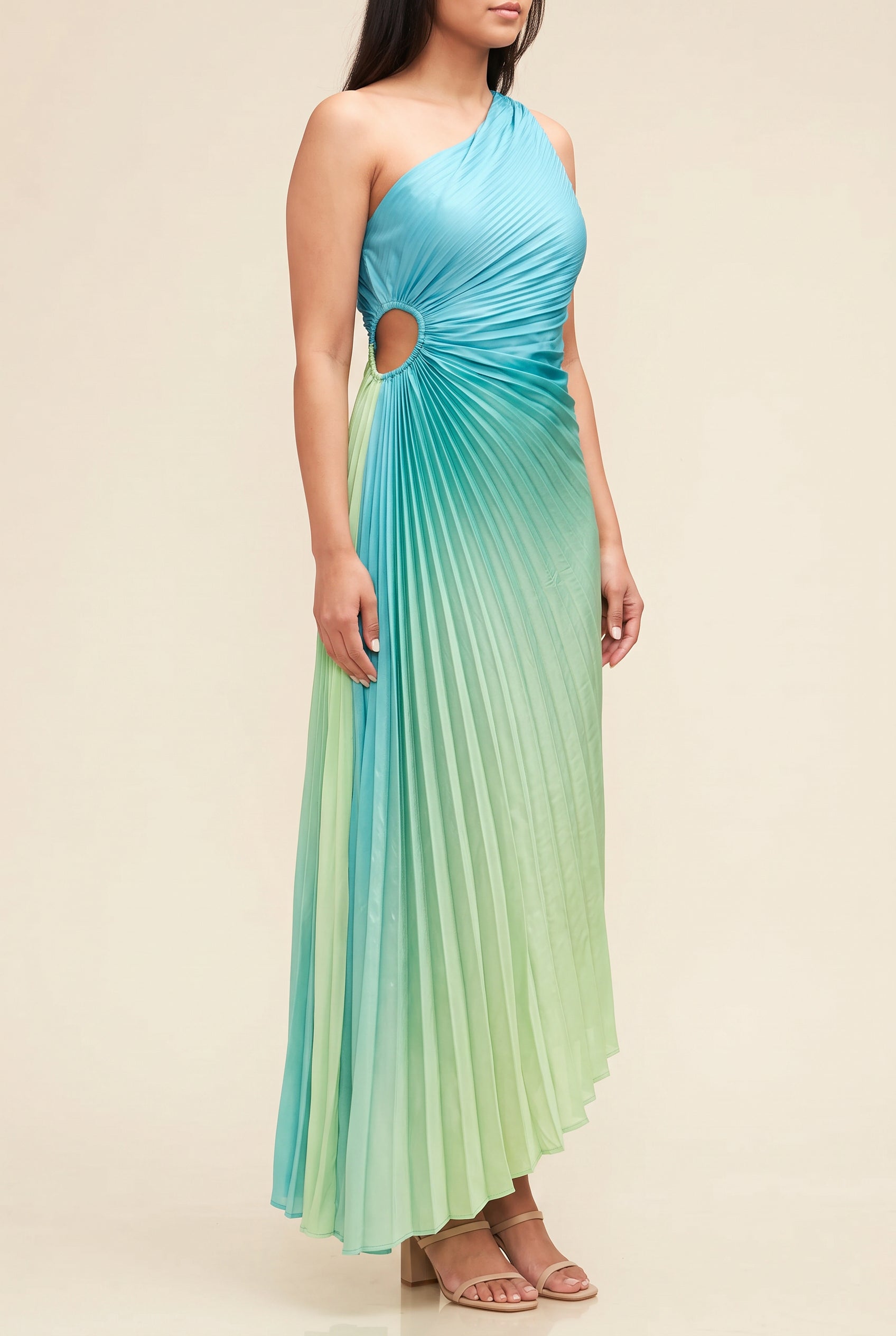 Angled side fit of the ombre pleated dress showing the waist cutout and dipped hem.