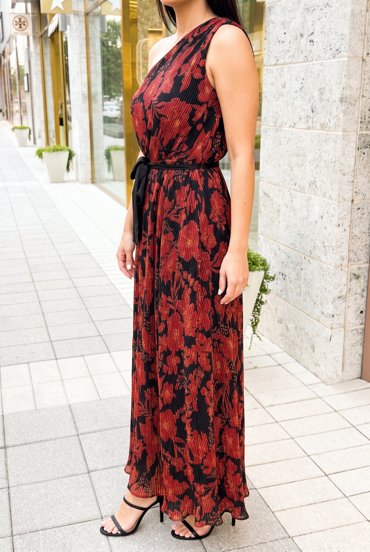 Angled side fit of the floral pleated maxi dress showing the bare-side coverage and waist drape.