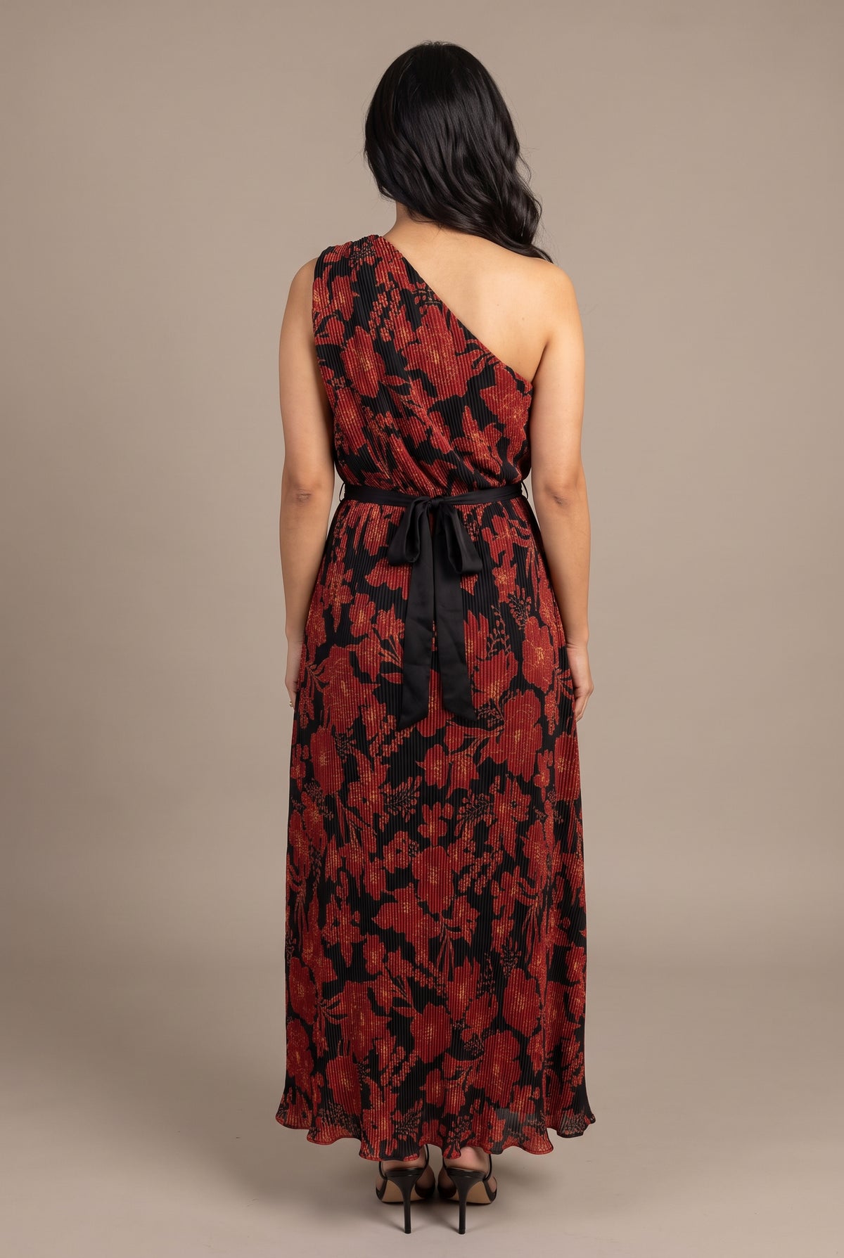 Back fit of the floral pleated one-shoulder maxi dress showing its asymmetric back and pleated length.