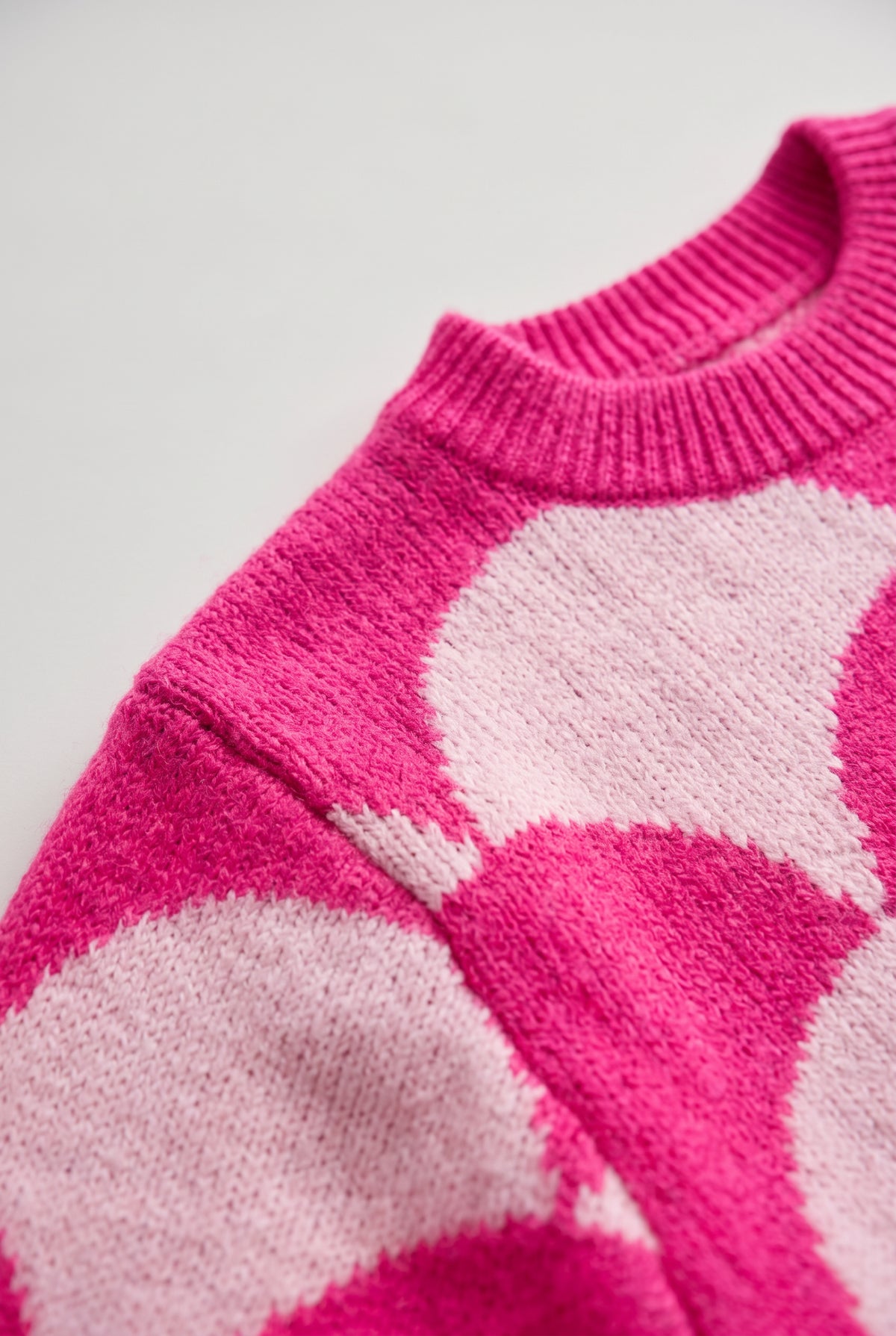 Close detail of the Say Something Sweater showing the ribbed neck, fuzzy knit, and pink pattern transition.