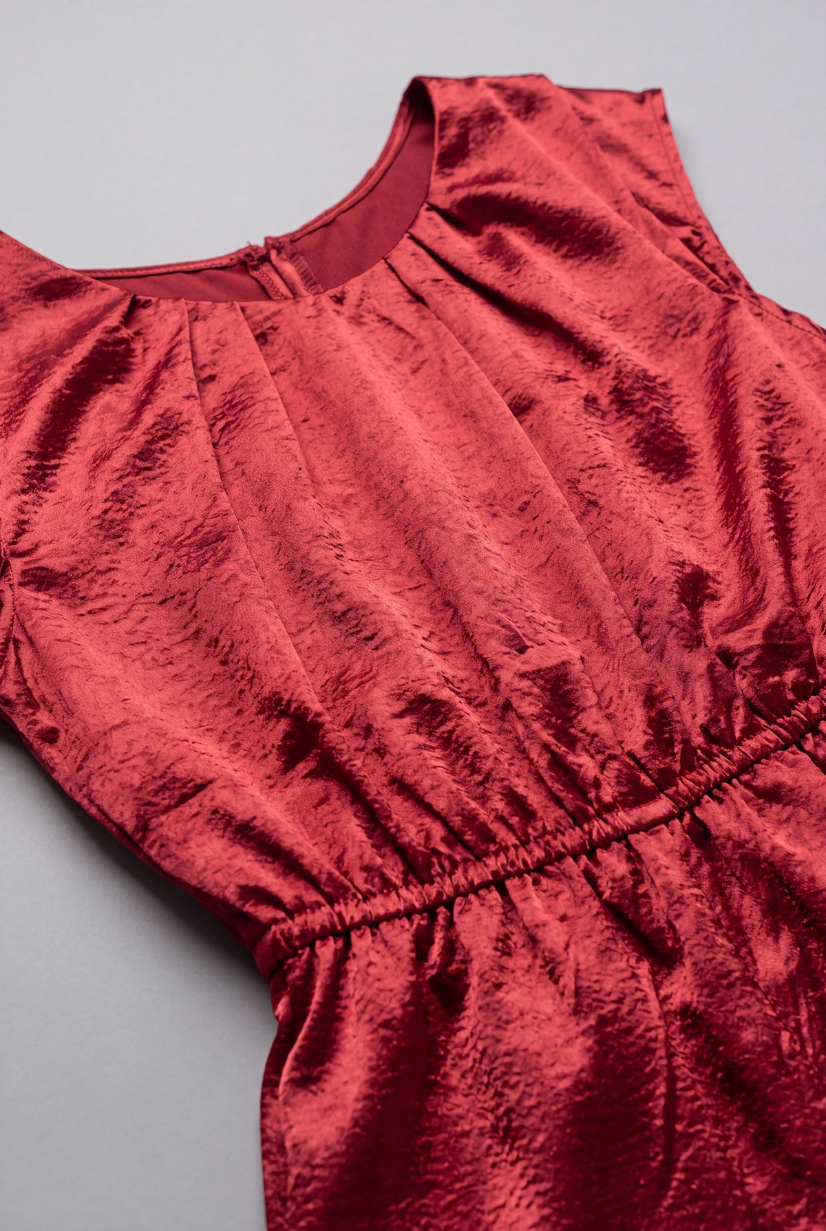 Close detail of the I'm Yours jumpsuit showing the ruby satin texture and gathered elastic waist.