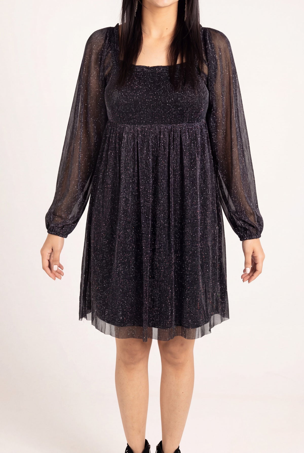 Close view of the black glitter dress showing sheer mesh, opaque lining and gathered waist seam.