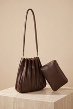 The Carrie chocolate pleated shoulder bag on its own, showing its shape.