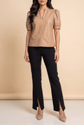 Front view of the latte split neck faux leather top showing the fit and length.