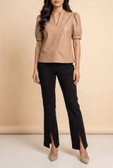 Front view of the latte split neck faux leather top showing the fit and length.