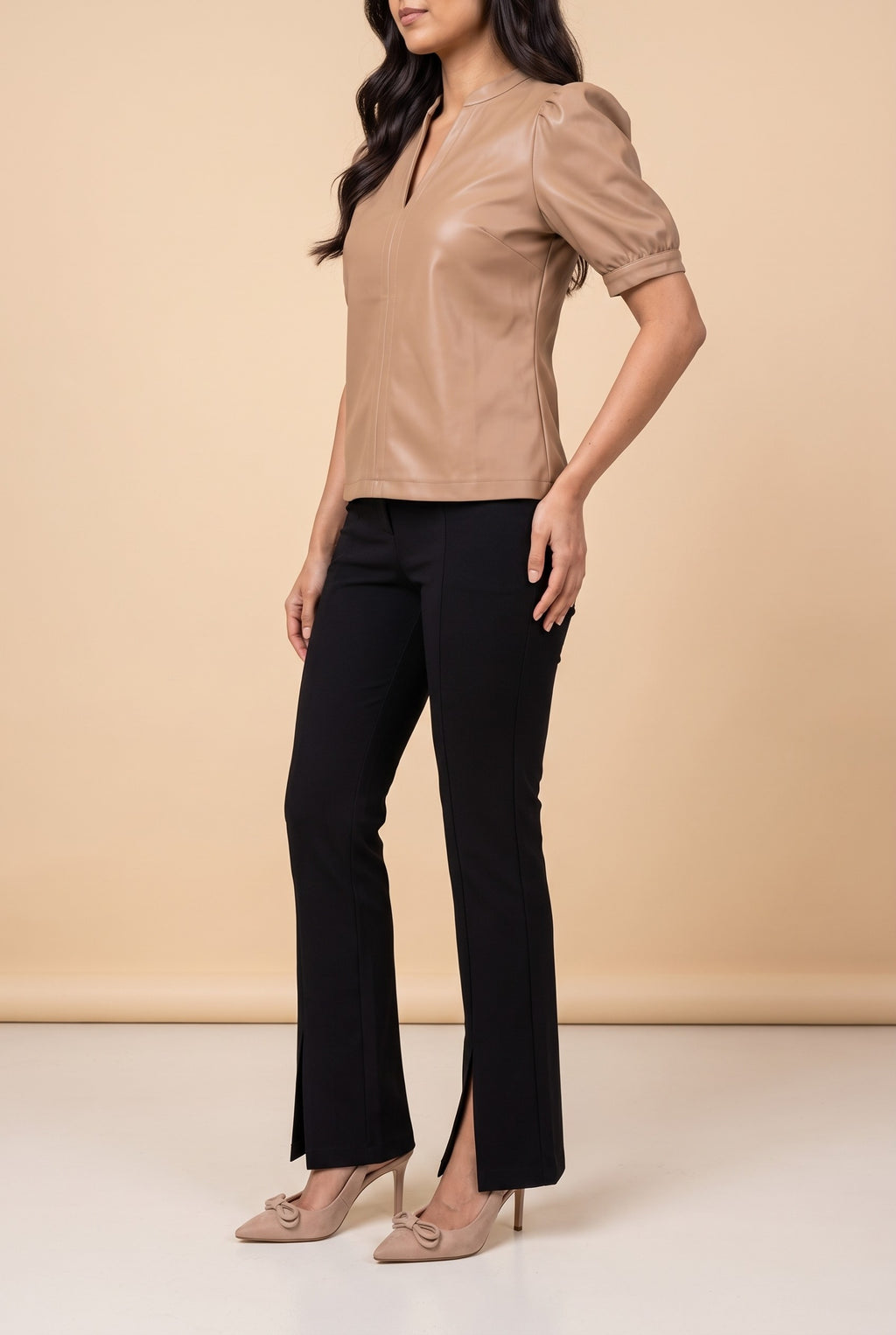 Side view of the latte split neck faux leather top showing the silhouette.